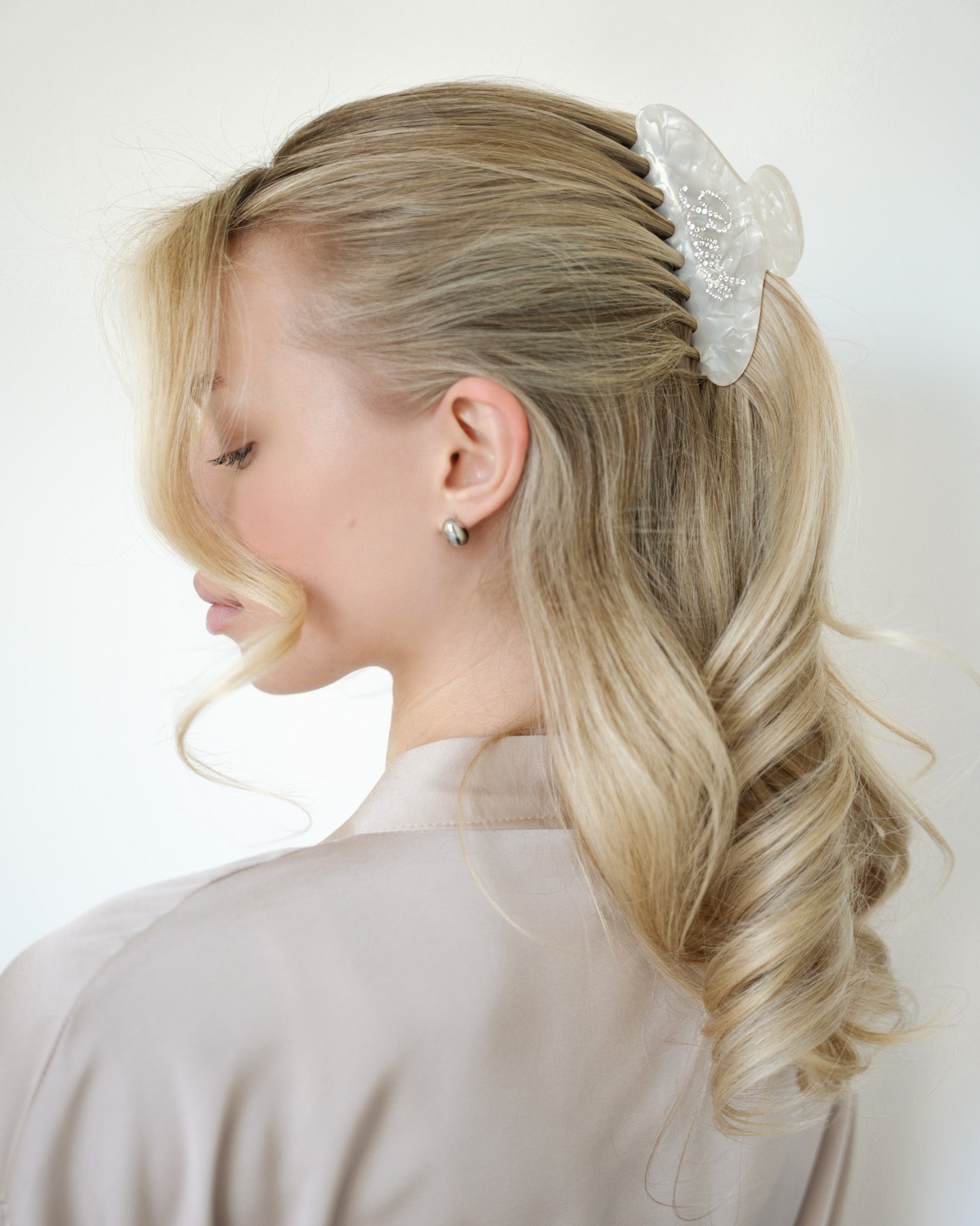 Woman with styled hair featuring a VESITIA bride claw clip on a white background