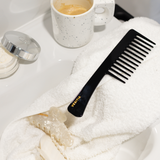Black VESITIA com on a white towel next to a mug and jar.