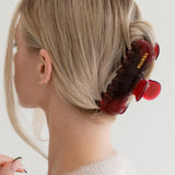 Woman with extra thick hair styling an updo using the VESITIA Maison Jumbo Claw Clip in Bordeaxu.