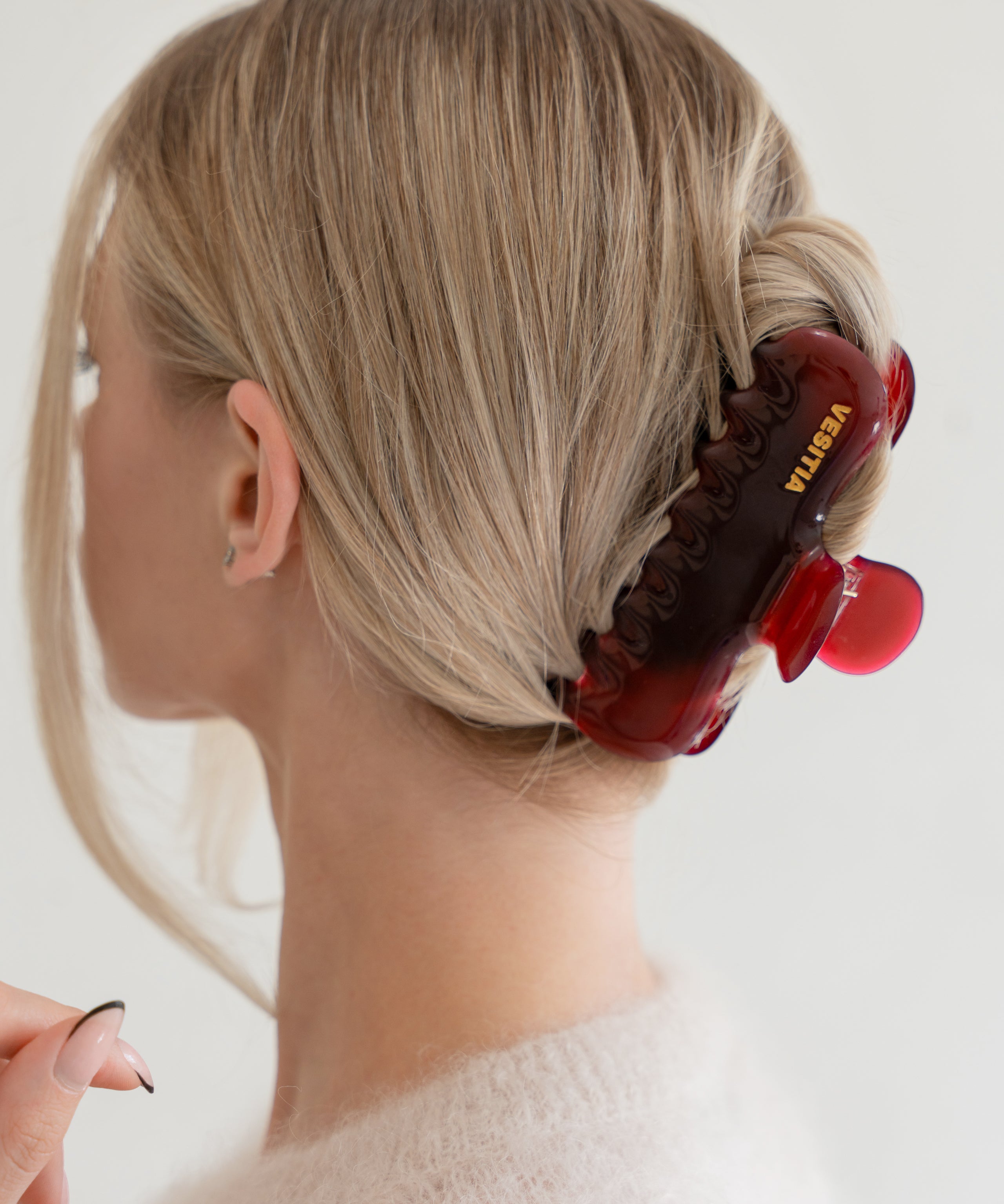 Woman with extra thick hair styling an updo using the VESITIA Maison Jumbo Claw Clip in Bordeaxu.