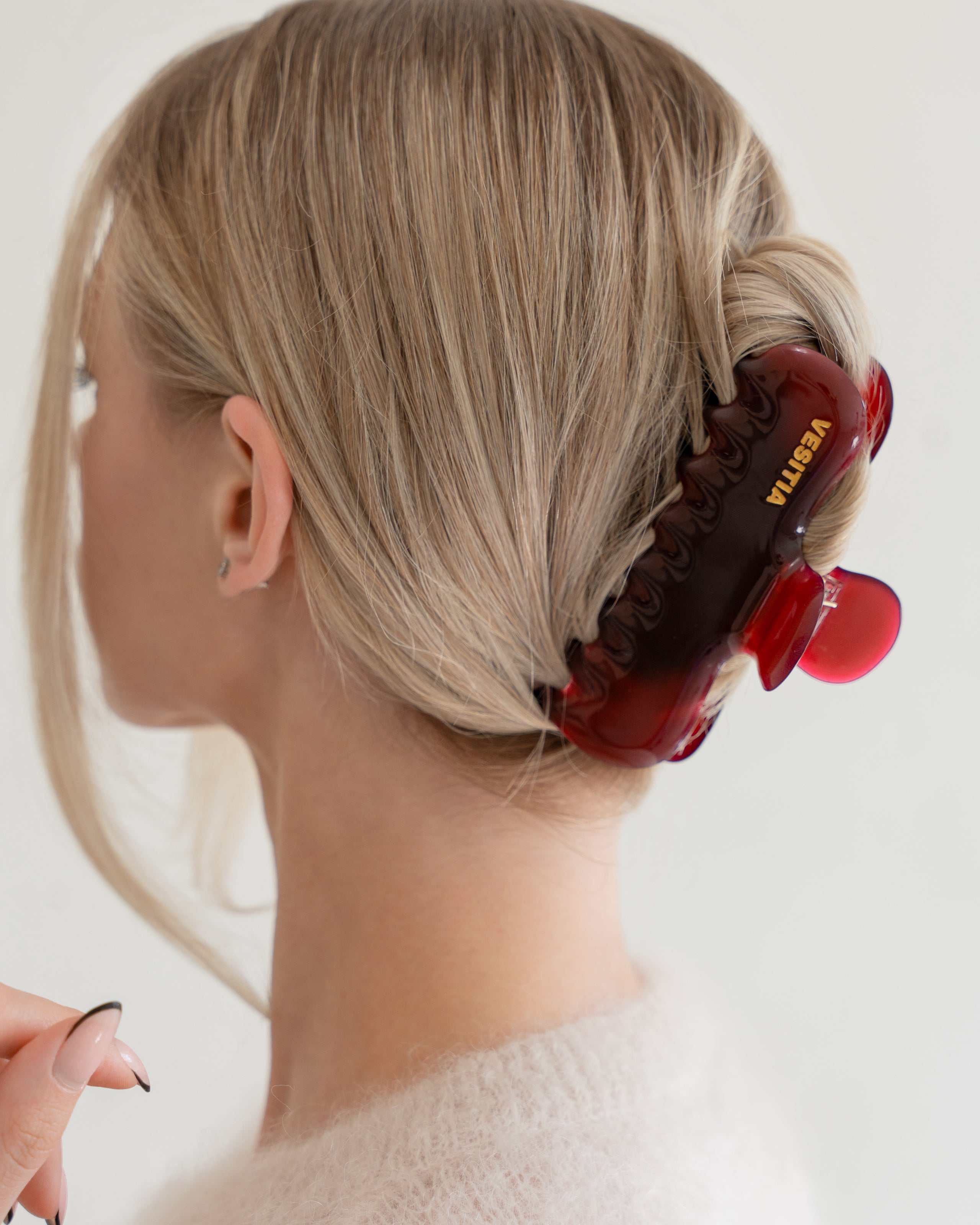 Woman with extra thick hair styling an updo using the VESITIA Maison Jumbo Claw Clip in Bordeaxu.