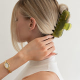 Woman with extra thick hair styling an updo using the VESITIA Maison Jumbo Claw Clip in Verde.