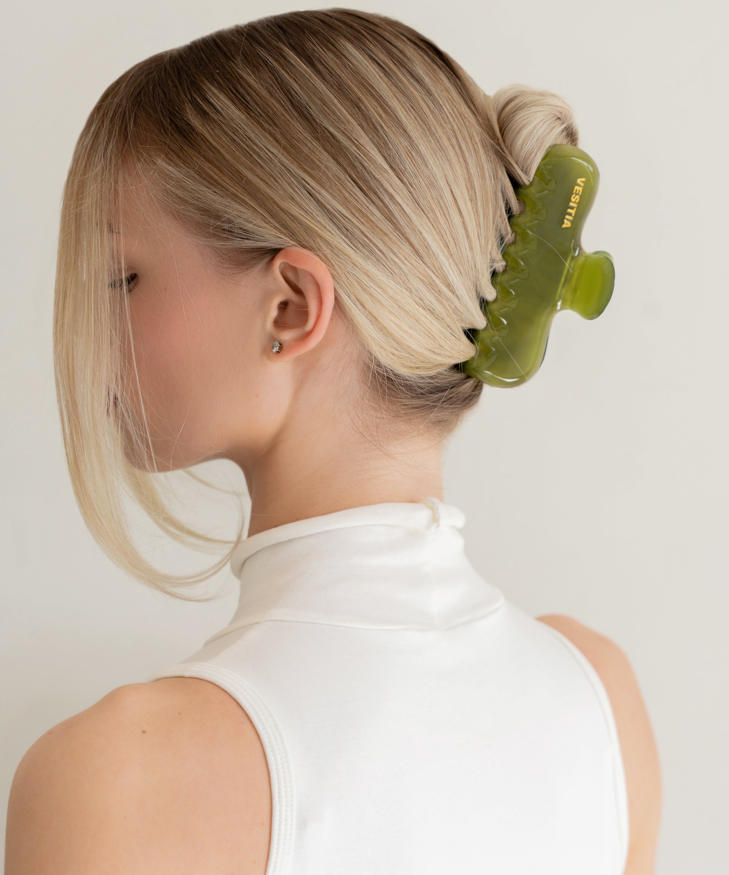 Woman with extra thick hair styling an updo using the VESITIA Maison Jumbo Claw Clip in Verde.