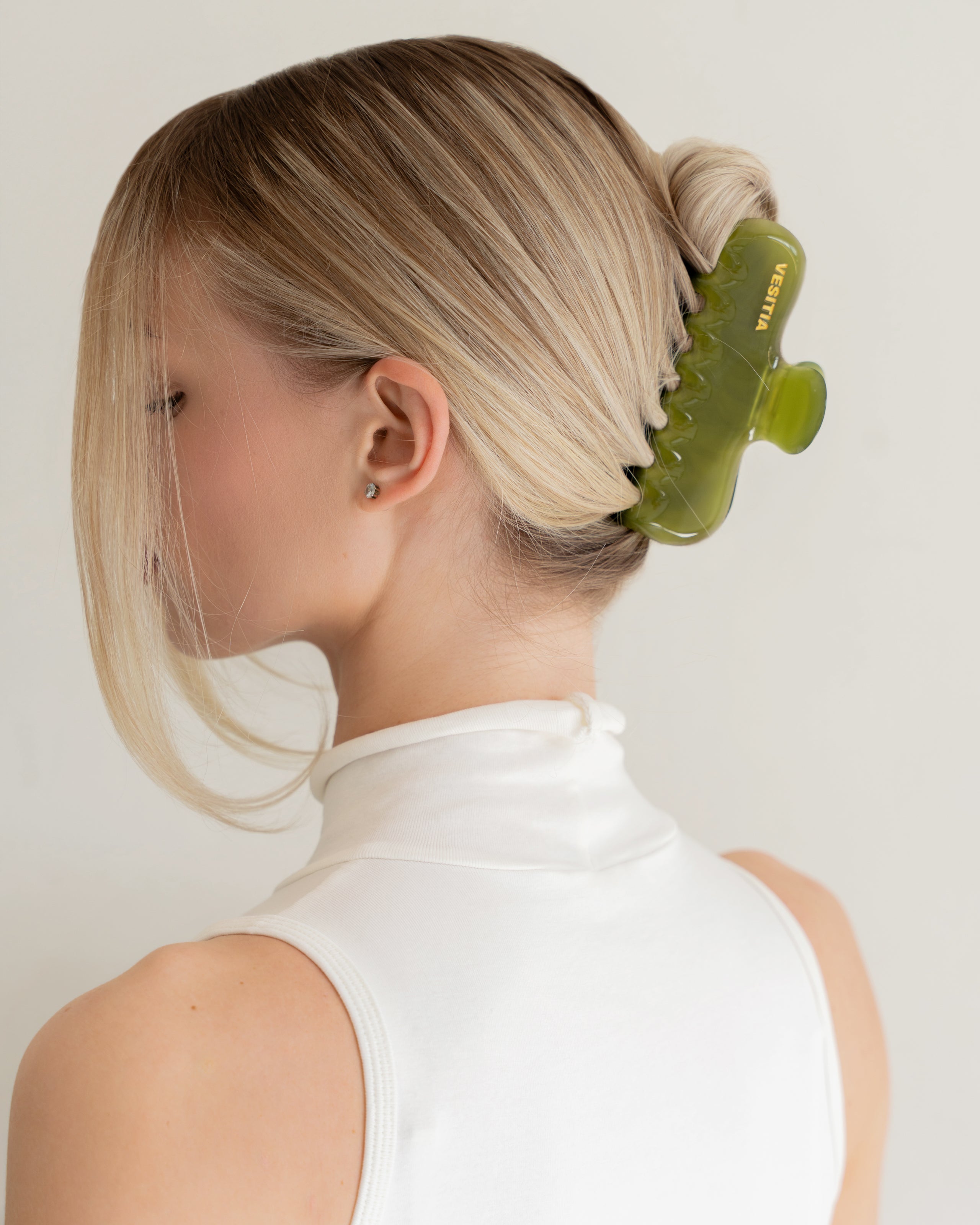 Woman with extra thick hair styling an updo using the VESITIA Maison Jumbo Claw Clip in Verde.