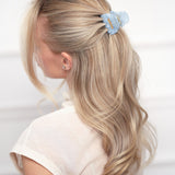 Woman with blonde hair wearing a blue VESITIA claw clip on a white background