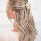 Person with blonde hair wearing a VESITIA hair claw clip on a white background