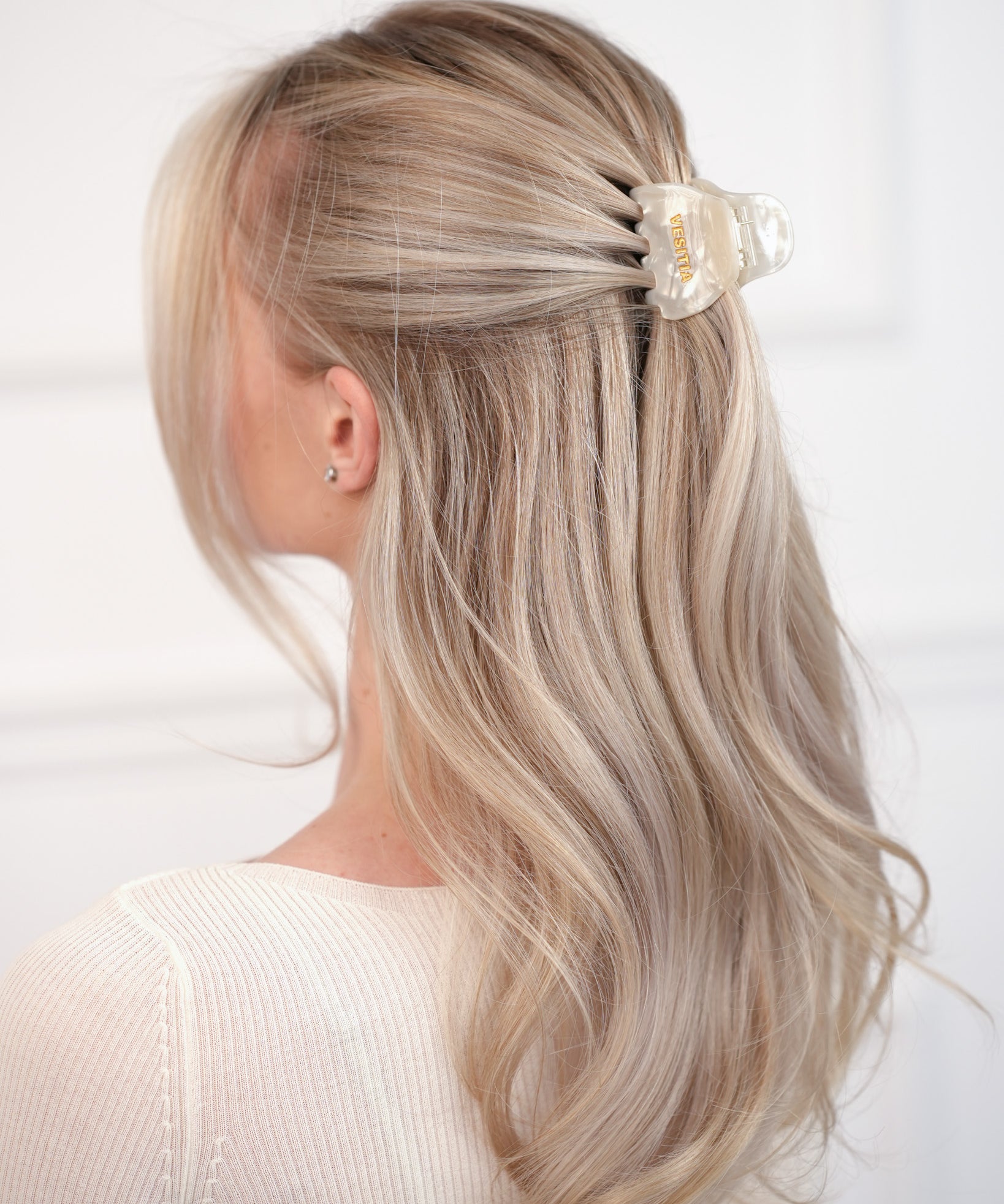 Person with blonde hair wearing a VESITIA hair claw clip on a white background