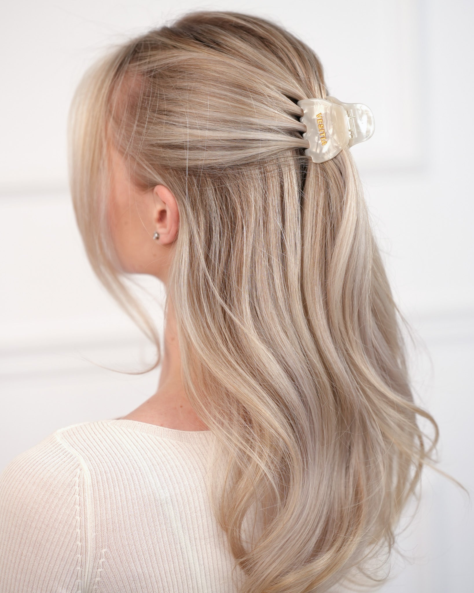 Person with blonde hair wearing a VESITIA hair claw clip on a white background
