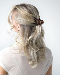 Person with blonde hair styled with a VESITIA midi claw clip on a white background