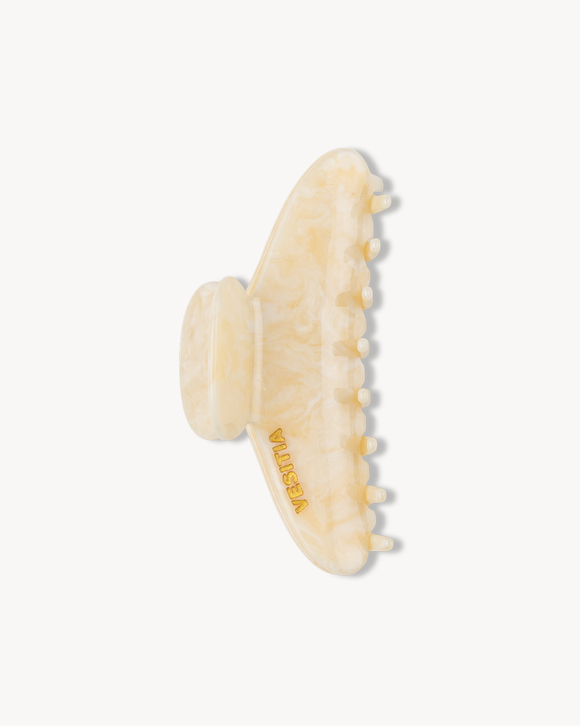 Beige VESITIA hair claw clip with a textured design on a white background