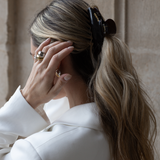 Woman with wearing a VESITIA claw clip and a white blazer against a neutral background