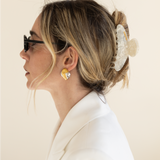 Woman with styled hair wearing a VESITIA claw clip against a beige background