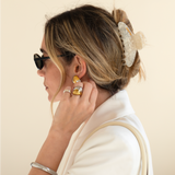 Woman wearing sunglasses and a VESITIA claw clip with a plain background